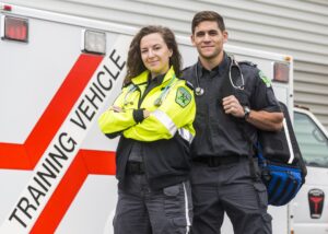 Two Paramedic students in front of training ambulance.