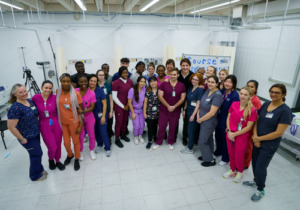 Nursing students stand are pictured in their scrubs with Prime Minister Justin Trudeau and Member of Parliament Anita Vandenbald. 