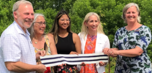 Outdoor shot of Claude Brule with Pembroke leaders at dedication of new medicine wheel garden. People in a line holding a wampum belt