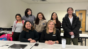 A group of Algonquin College students and Employee standing in a classroom smiling