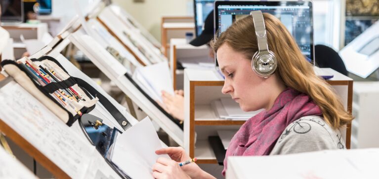 Animation student poses for photo while in a drawing course. 