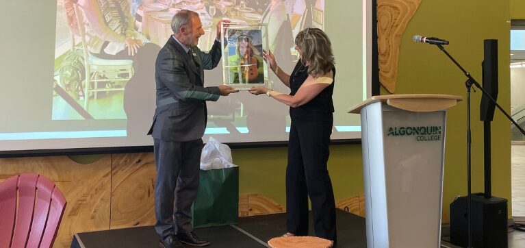 President Claude Brulé gifting Laura Stanbra a caricature. 