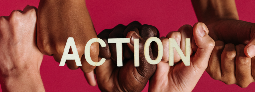 Fists of several shades/colours behind the word ACTION on a red background