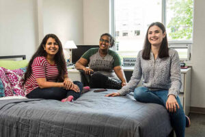 A group of women sitting on a bed in AC Residence.