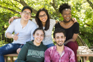 five students sitting at a picnic table.