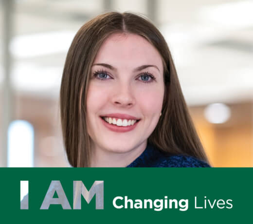 A brunette woman smiling with text that reads I AM Changing Lives.