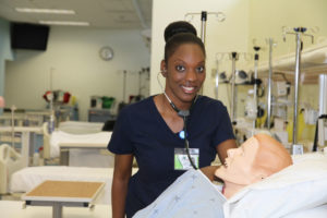 nursing student working with a mannequin inside the simulation health lab