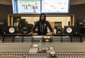 student standing by a large mixer board