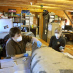 People restoring the bottom of a canoe