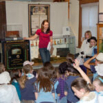 Museum guide presenting to a group of children