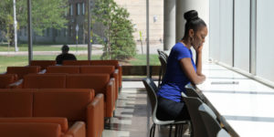 student sitting in a lounge area on campus