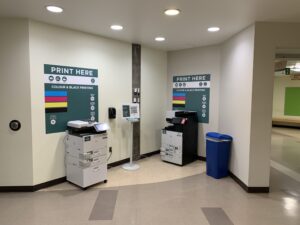 An image of two Ricoh multi function printers located on the second floor of B building in the hallway close to the link to ACCE building.