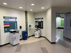 An image of two Ricoh multi function printers located on the second floor of B building in the hallway close to the link to ACCE building.