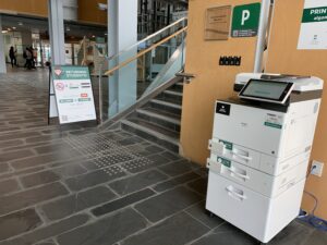 An image of a Ricoh multi function printer located on the first floor of ACCE building near the stairs. 