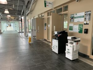 Image of two Ricoh multi function printers located on the second floor of ACCE building near the link to B building.