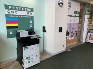 An image of a Ricoh multi function printer located on the first floor of E building in the hallway across from Starbucks.