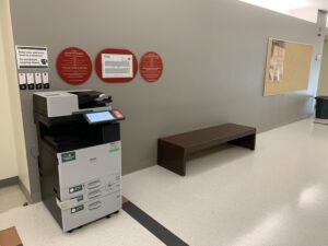 An image of a Ricoh multi function printer located on the third floor of J building in the hallway outside of room J310.