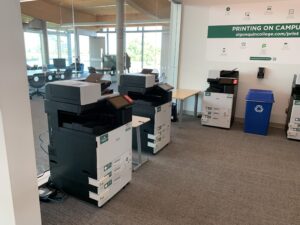 An image of two Ricoh multi function printers located on the third floor of C building, in the Library Print Copy Scan room.