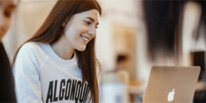 Student smiling at their laptop