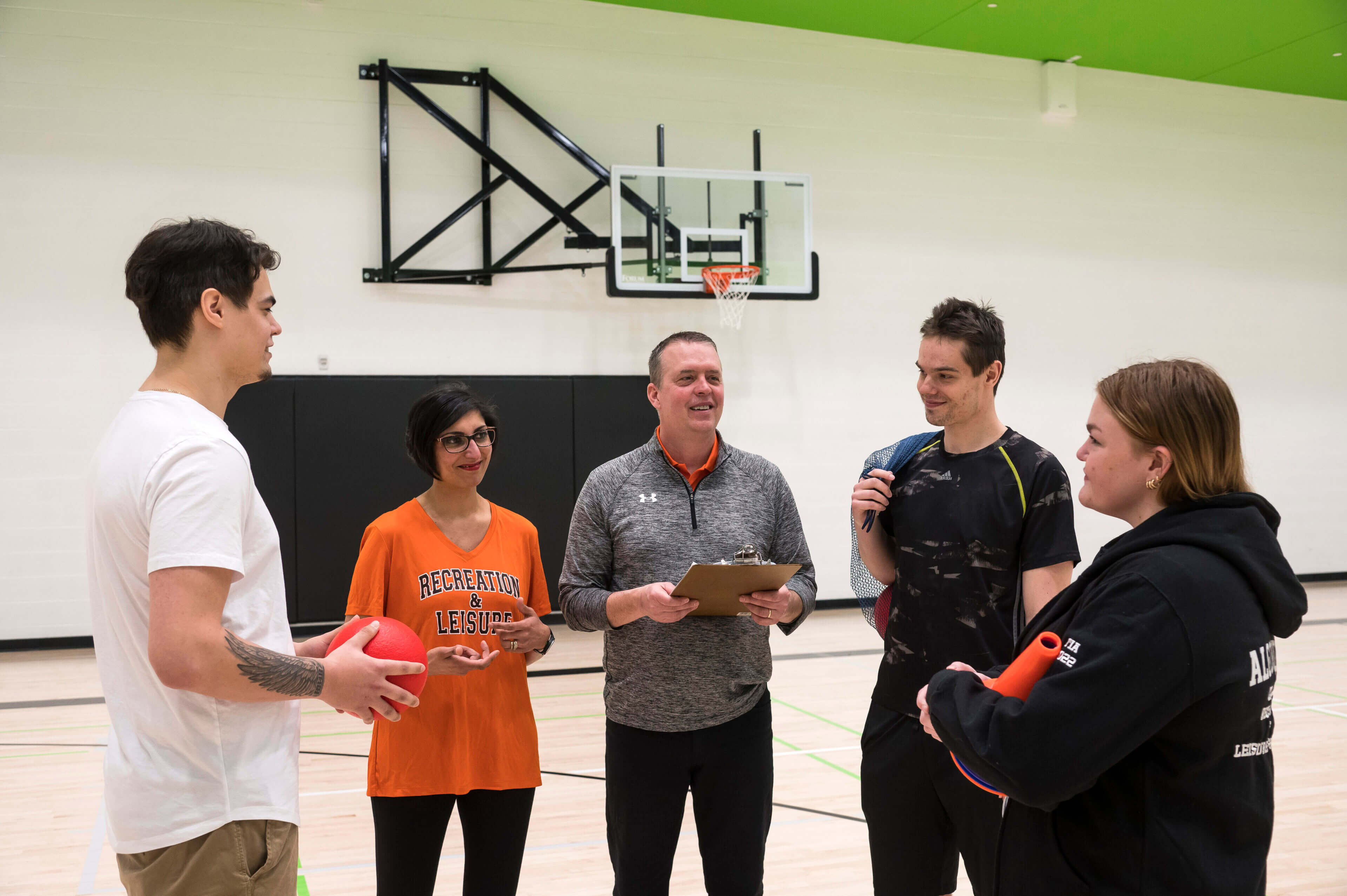 Recreation and Leisure Services students planning an activity with the professor in the athletics and recreation centre at the college